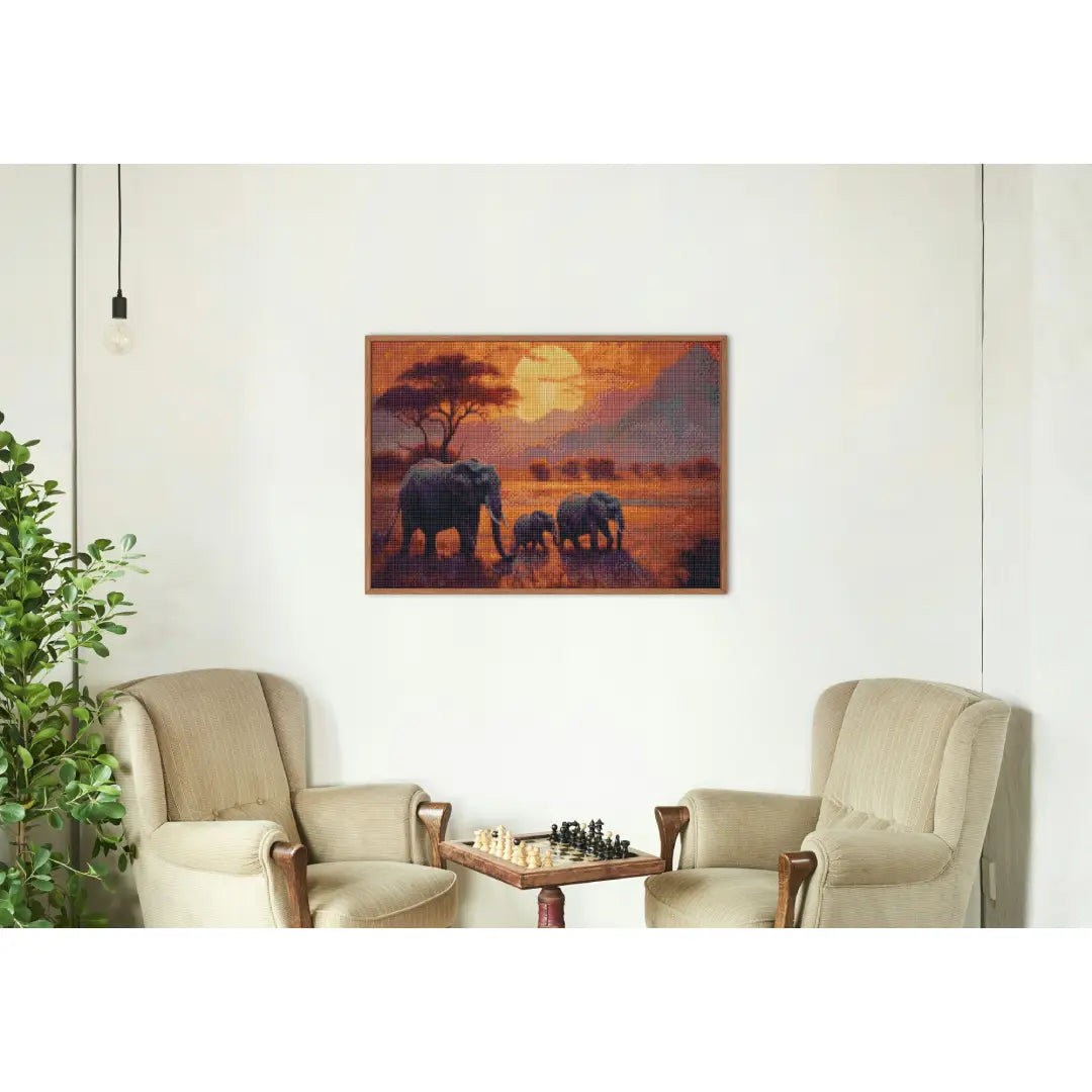 Diamond painting van een olifantenfamilie bij zonsondergang, aan de muur tussen twee beige fauteuils met een schaakbord op een tafeltje.